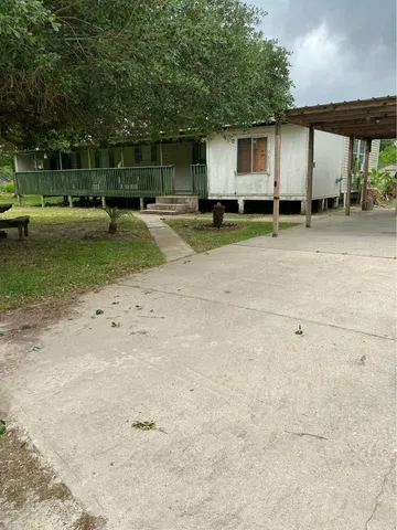 a backyard of a house with barbeque oven table and chairs