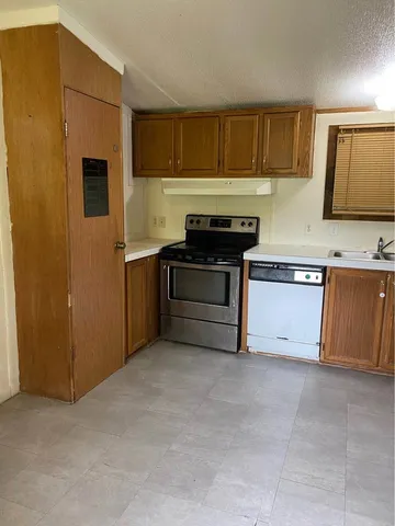 a kitchen with stainless steel appliances granite countertop a stove a refrigerator and a sink