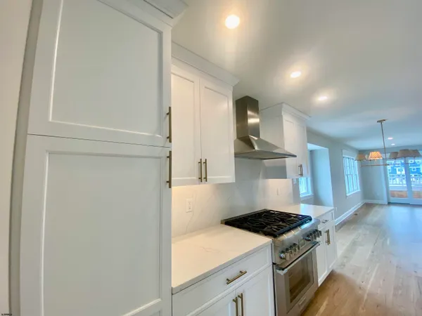 a view of a refrigerator in kitchen and white cabinets