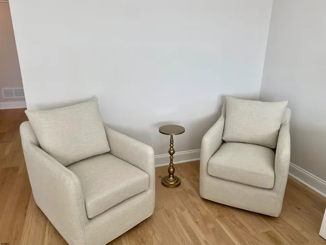 a bedroom with a white bed and wooden floor