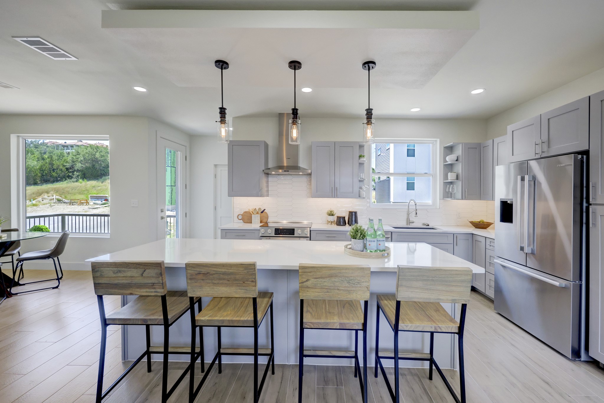 4300 Mansfield Dam Road, Unit 1221 Austin, TX 78734 - Photo 30 of 38 a kitchen with stainless steel appliances granite countertop a dining table chairs refrigerator and wooden floor