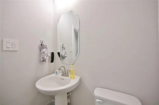 a spacious en suite bathroom with a double vanity sink a mirror and a bathtub