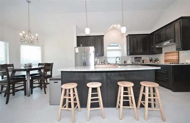 a kitchen with stainless steel appliances granite countertop a sink stove and refrigerator