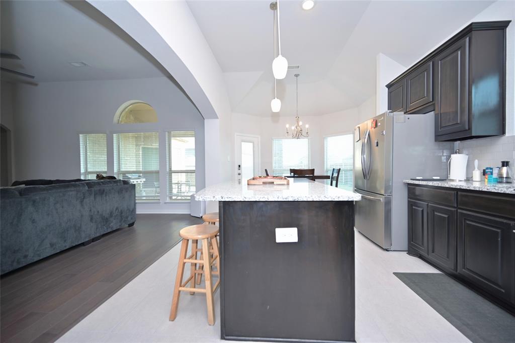 1802 Ranch View Drive Cedar Hill, TX 75104 - Photo 6 of 40 a kitchen with stainless steel appliances granite countertop a refrigerator a stove a sink dishwasher a dining table and chairs with wooden floor