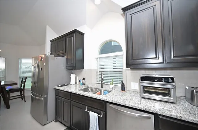 a kitchen with stainless steel appliances granite countertop a stove and a refrigerator