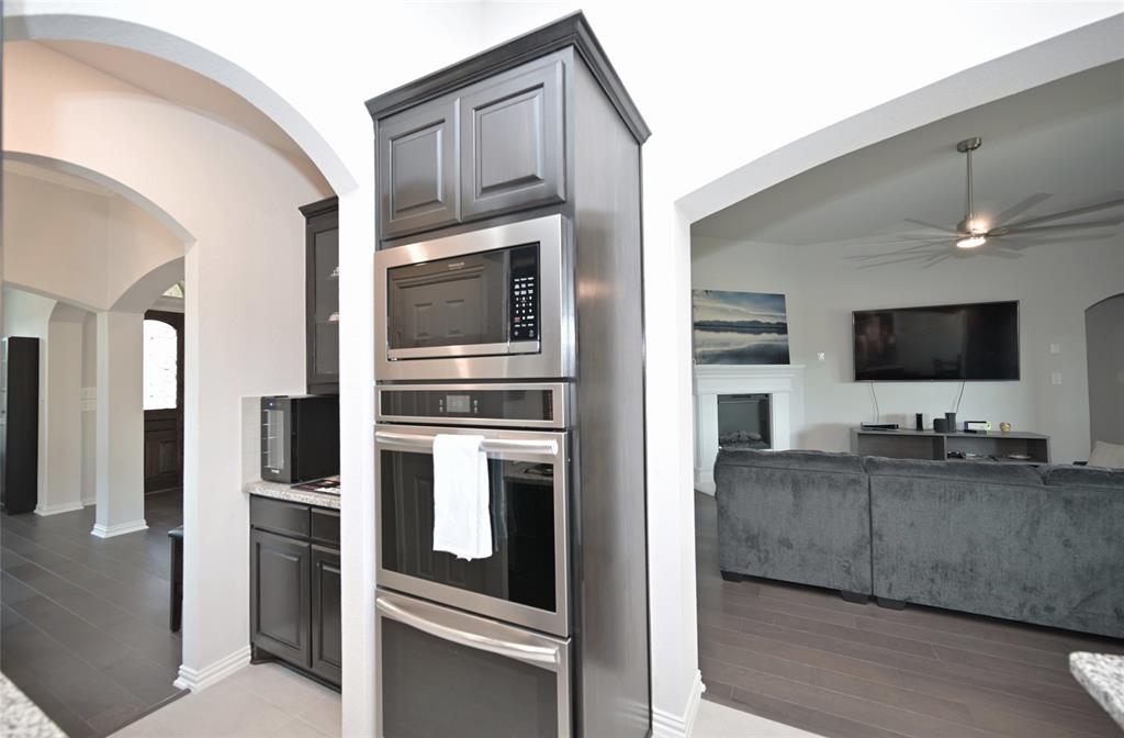 1802 Ranch View Drive Cedar Hill, TX 75104 - Photo 9 of 40 a kitchen with stainless steel appliances kitchen island granite countertop a stove and a microwave