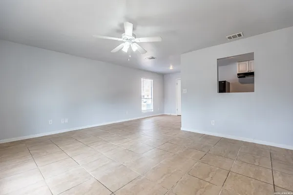 an empty room with fan and windows