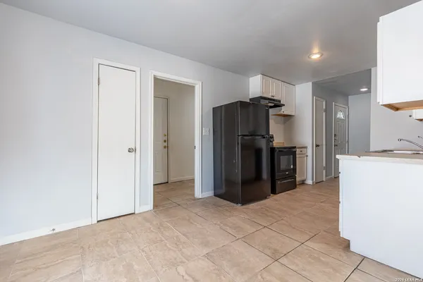 a kitchen with kitchen island a refrigerator and a refrigerator