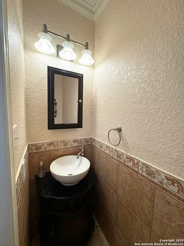 a bathroom with a toilet a sink and wooden floor