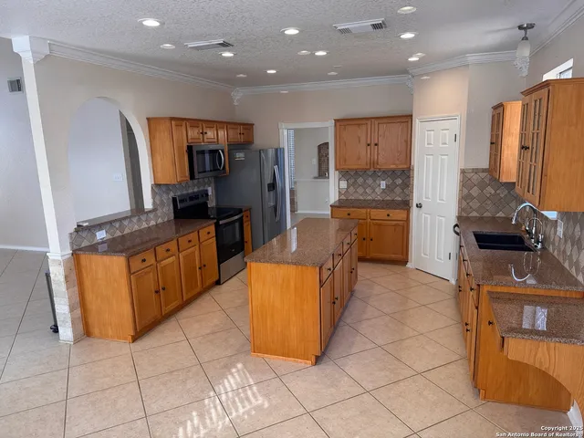 a kitchen with stainless steel appliances granite countertop a refrigerator and a stove