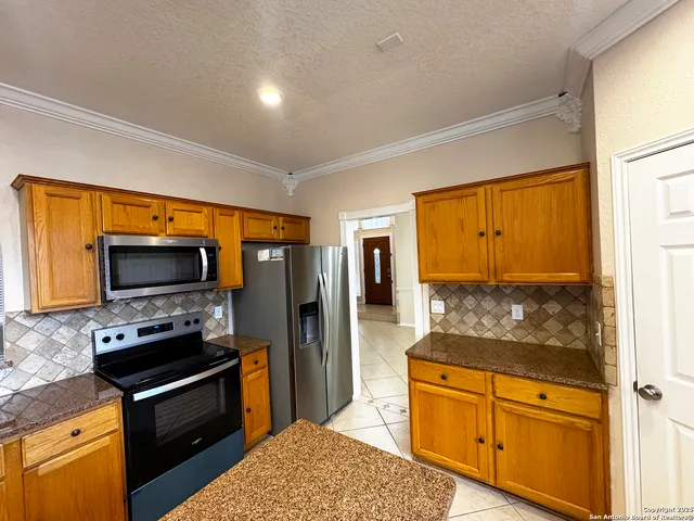 a kitchen with stainless steel appliances a stove microwave and refrigerator
