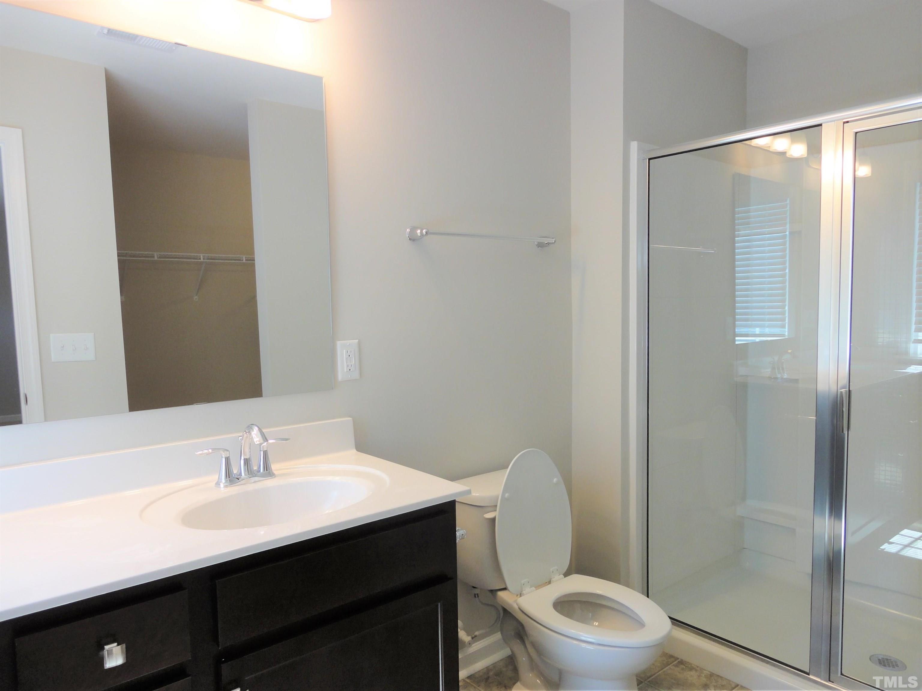 565 Metro Station Apex, NC 27502 - Photo 18 of 29 a bathroom with a sink a toilet a shower and a mirror