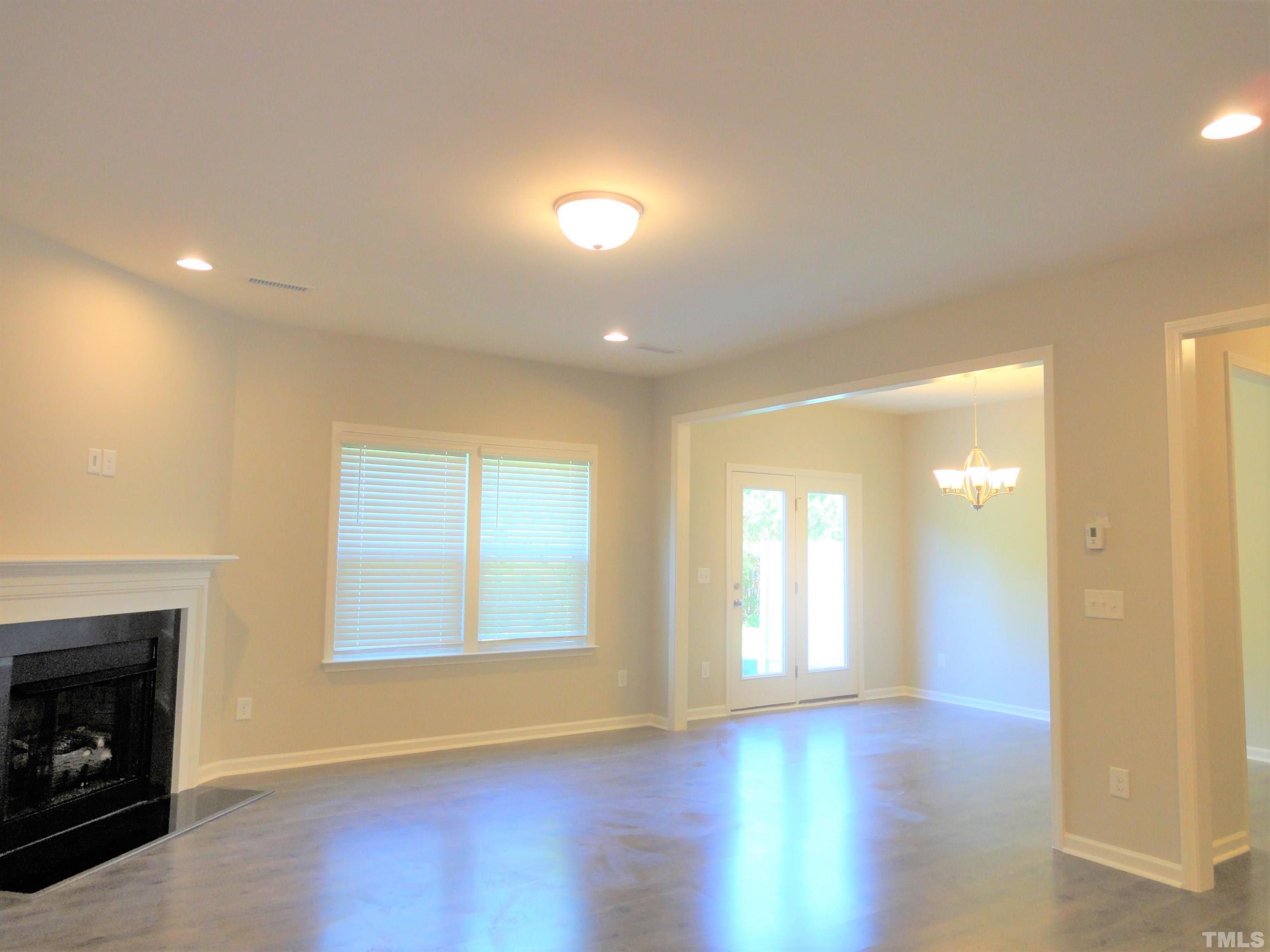 565 Metro Station Apex, NC 27502 - Photo 4 of 29 a view of an empty room with wooden floor and a window