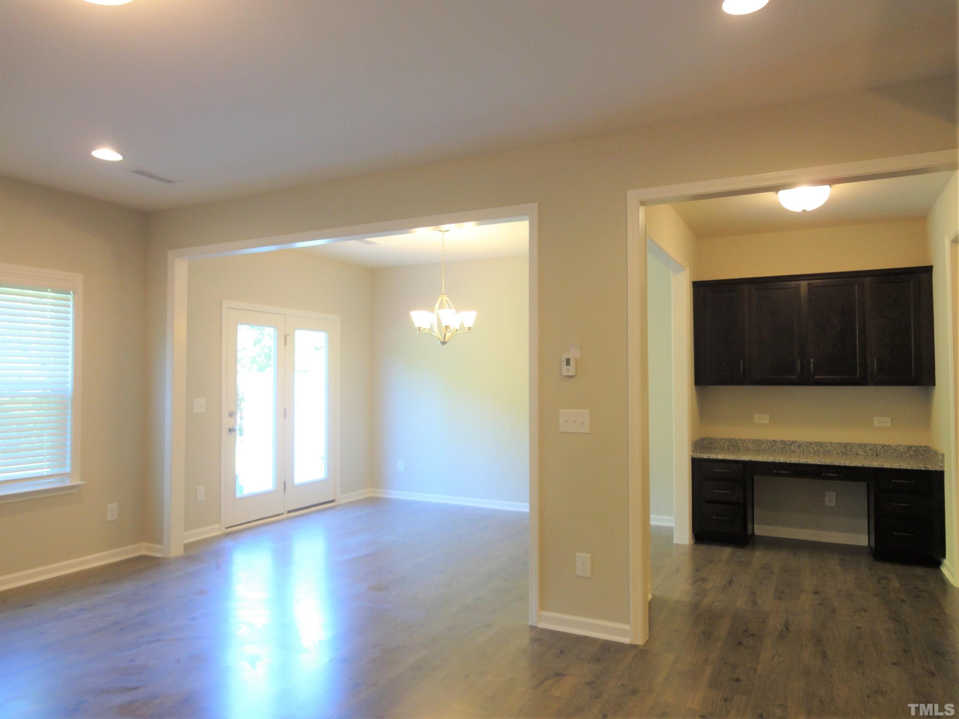 565 Metro Station Apex, NC 27502 - Photo 5 of 29 an empty room with wooden floor and windows
