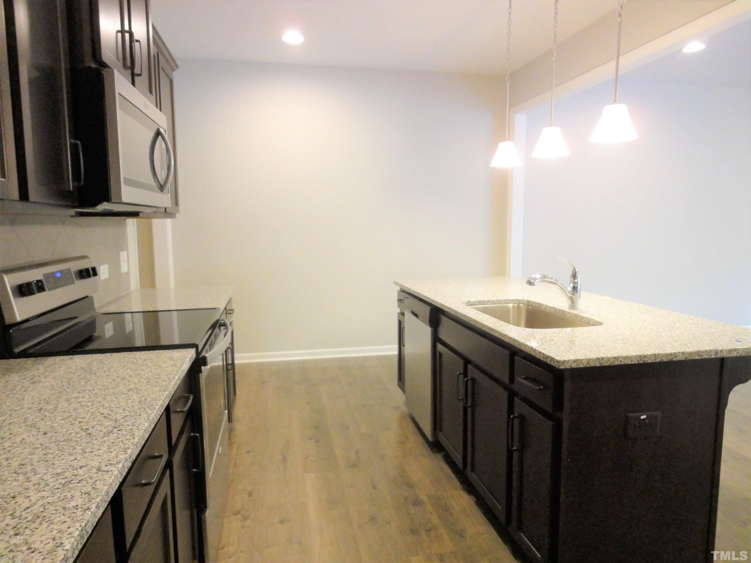 565 Metro Station Apex, NC 27502 - Photo 10 of 29 a kitchen with a sink a microwave and cabinets