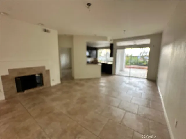 a view of an empty room with a fireplace and a window