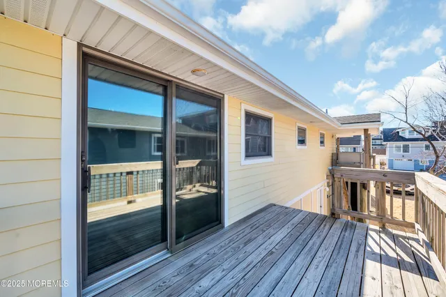 a view of a roof deck with table and chairs under an umbrella