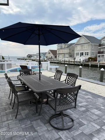 a roof deck view with table and chairs and wooden floor