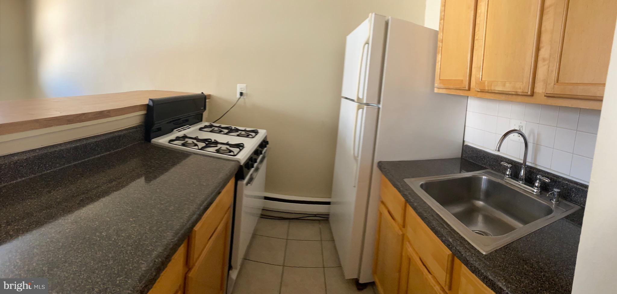 9323 Matador Road, Unit A Columbia, MD 21045 - Photo 5 of 9 a kitchen that has a sink and a stove