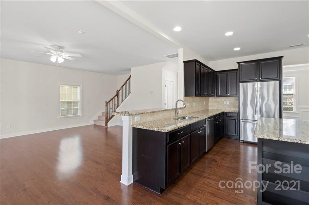 4331 Oxford Mill Road Waxhaw, NC 28173 - Photo 16 of 48 a kitchen with stainless steel appliances granite countertop a sink a stove a refrigerator cabinets and wooden floor