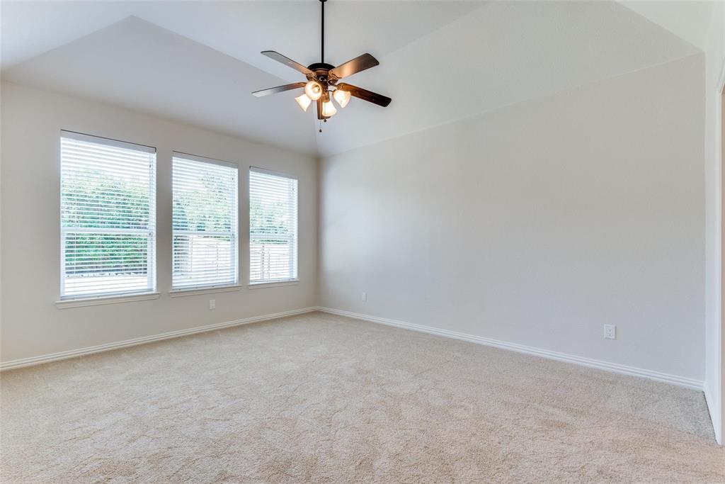 2344 Ranchview Drive Little Elm, TX 75068 - Photo 19 of 24 Spacious room with plush carpeting, three large windows with blinds, a tray ceiling, and a ceiling fan with integrated lighting