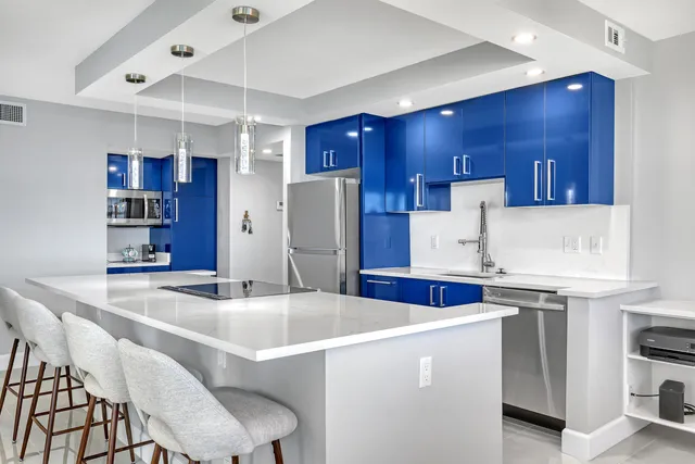 a kitchen with stainless steel appliances a table chairs and a refrigerator