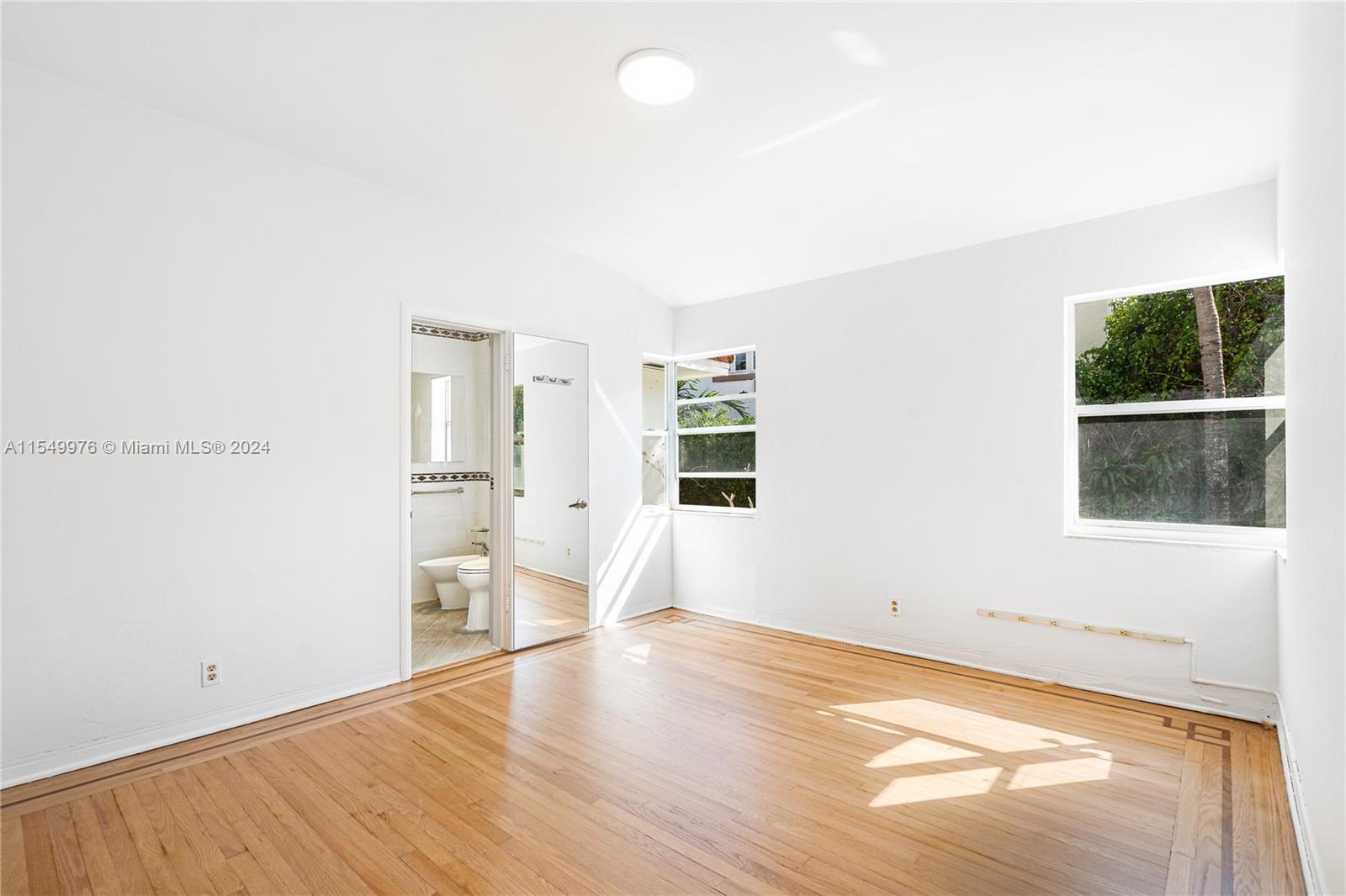2935 North Bay Road Miami Beach, FL 33140 - Photo 16 of 36 a view of empty room with wooden floor and window