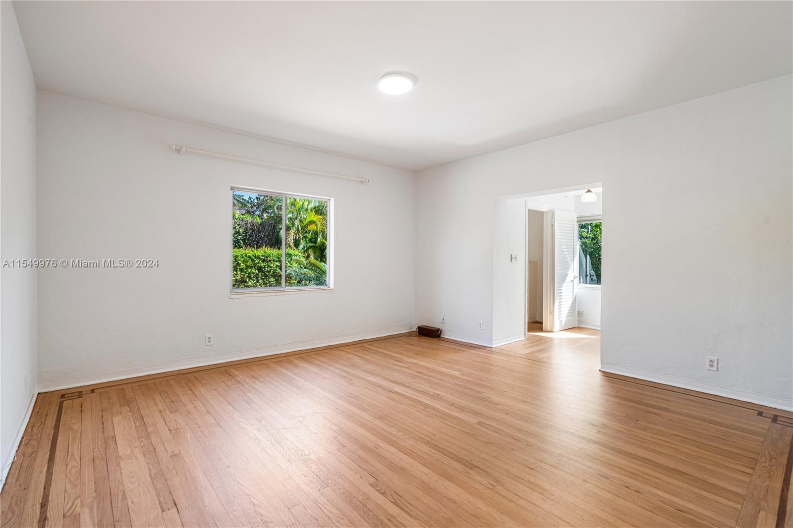 2935 North Bay Road Miami Beach, FL 33140 - Photo 19 of 36 an empty room with wooden floor and windows