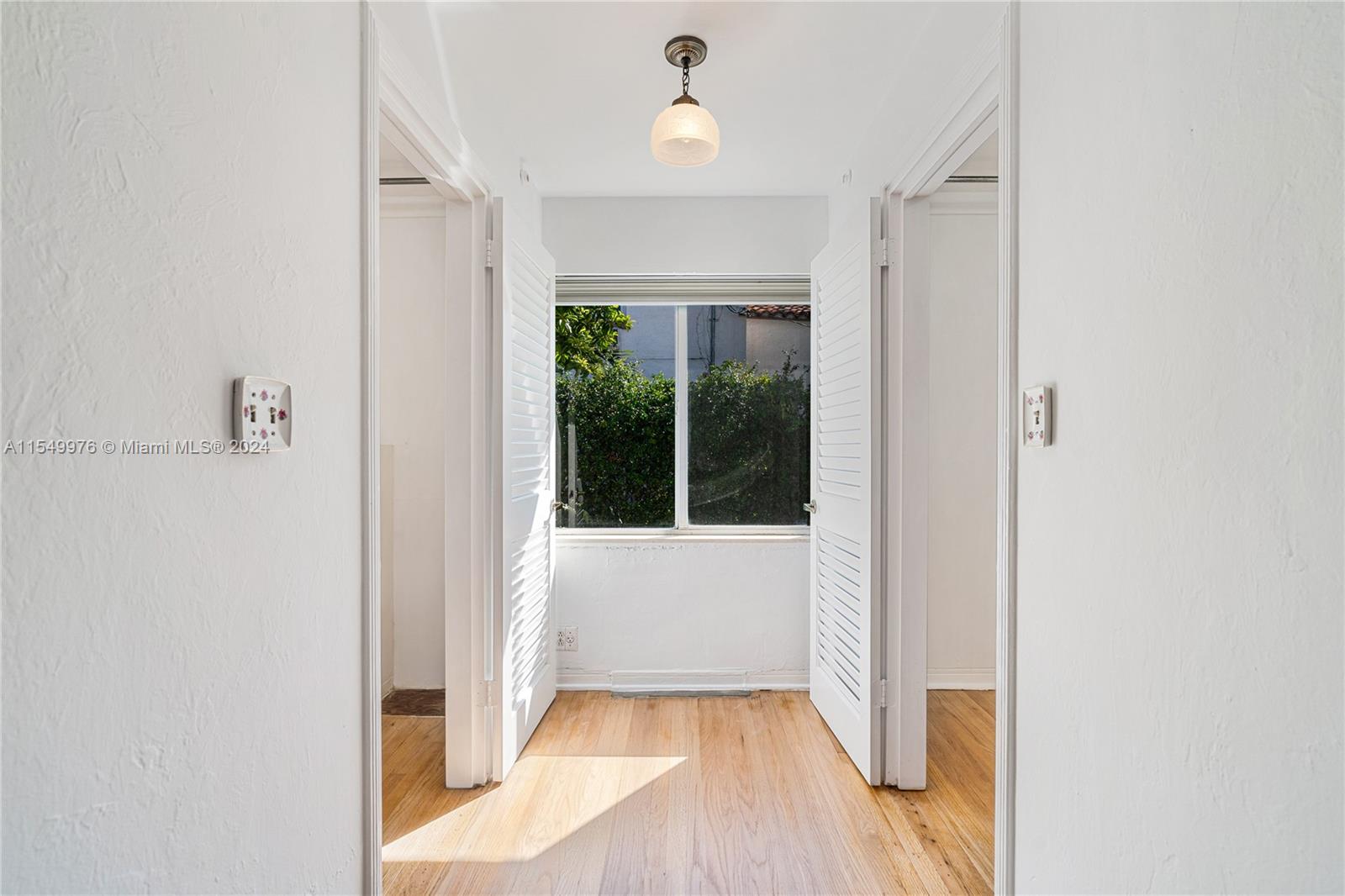 2935 North Bay Road Miami Beach, FL 33140 - Photo 20 of 36 a view of a hallway with wooden floor and a window
