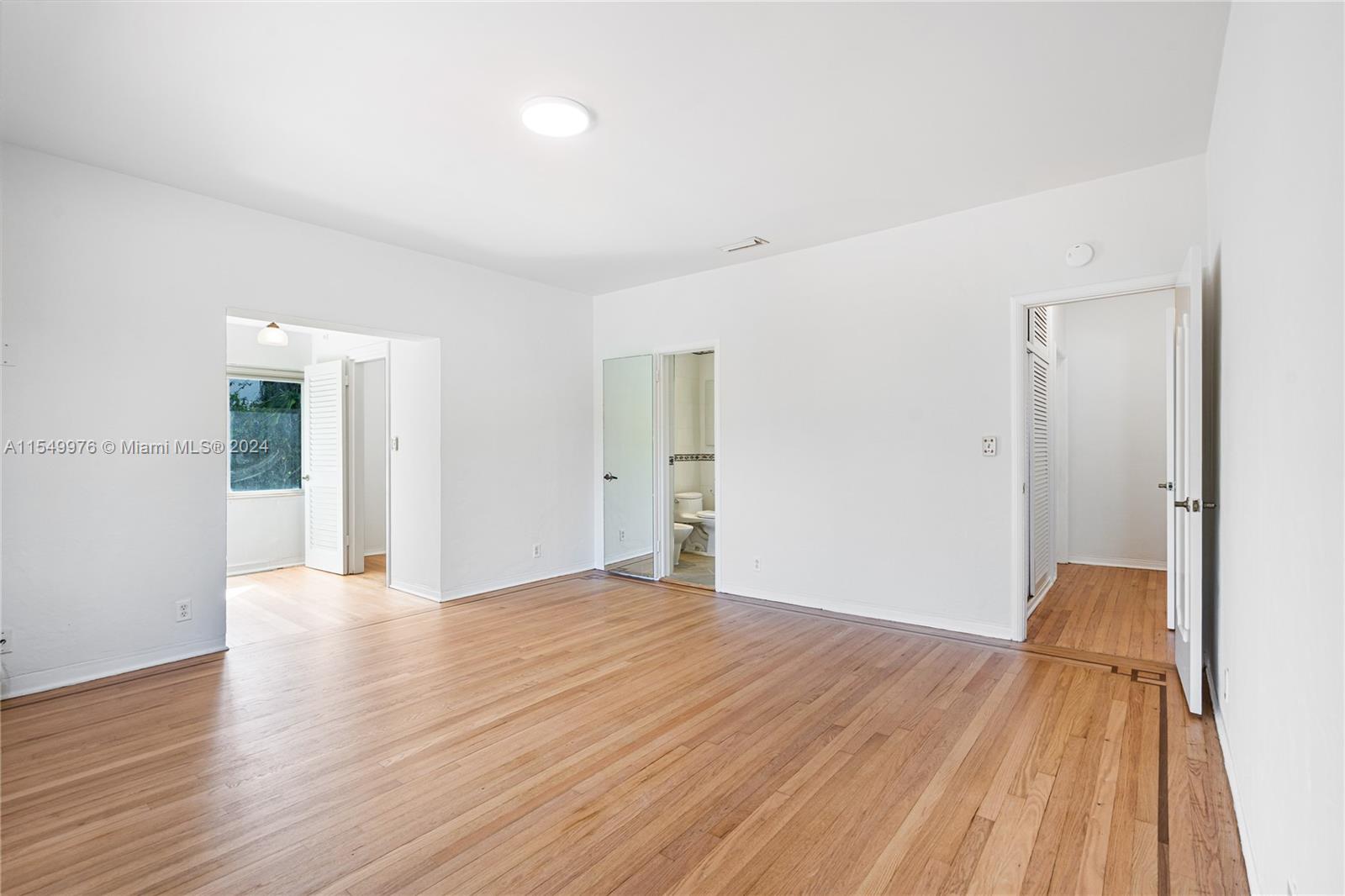2935 North Bay Road Miami Beach, FL 33140 - Photo 21 of 36 a view of a big room with wooden floor and windows