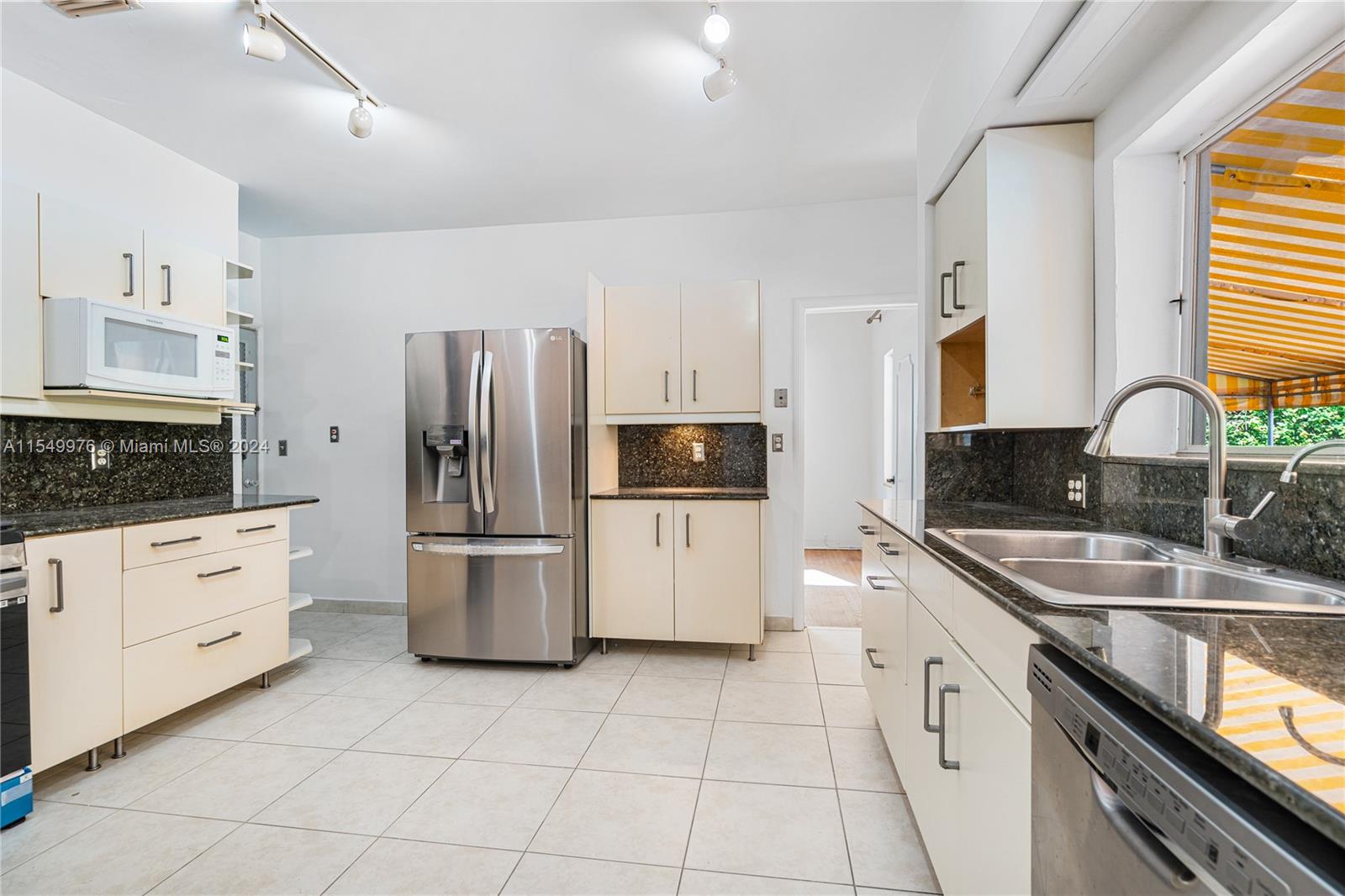 2935 North Bay Road Miami Beach, FL 33140 - Photo 22 of 36 a kitchen with a sink cabinets and stainless steel appliances