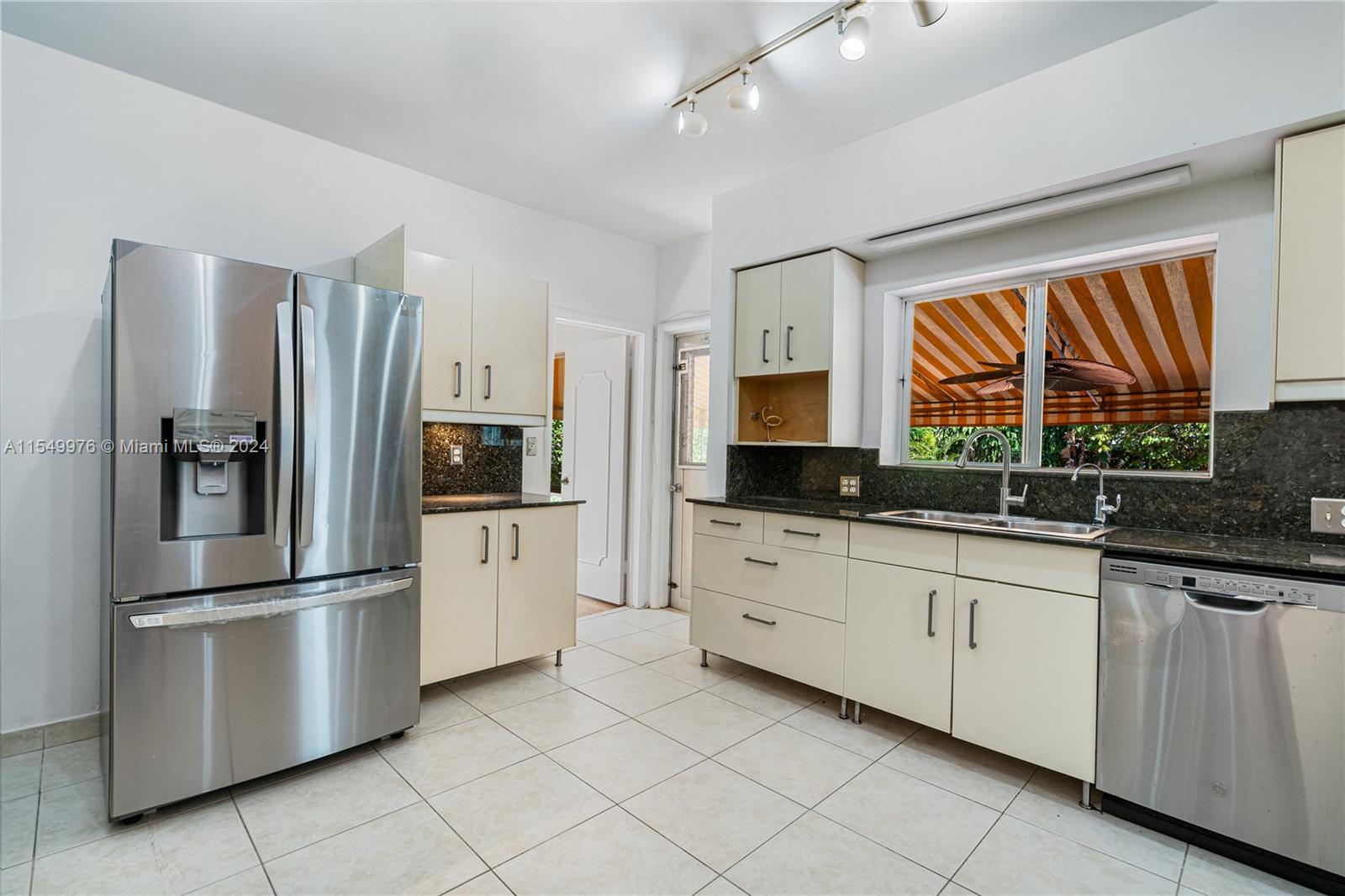2935 North Bay Road Miami Beach, FL 33140 - Photo 23 of 36 a kitchen with stainless steel appliances granite countertop a refrigerator and a sink