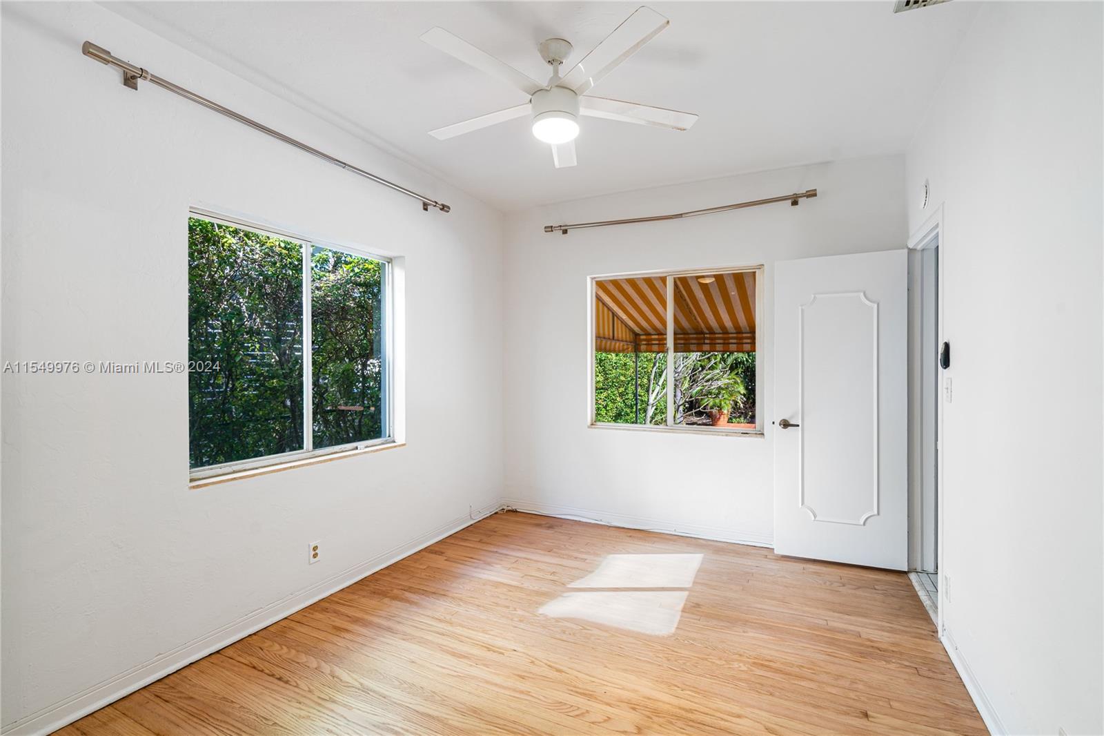 2935 North Bay Road Miami Beach, FL 33140 - Photo 26 of 36 a view of an empty room with wooden floor and a window