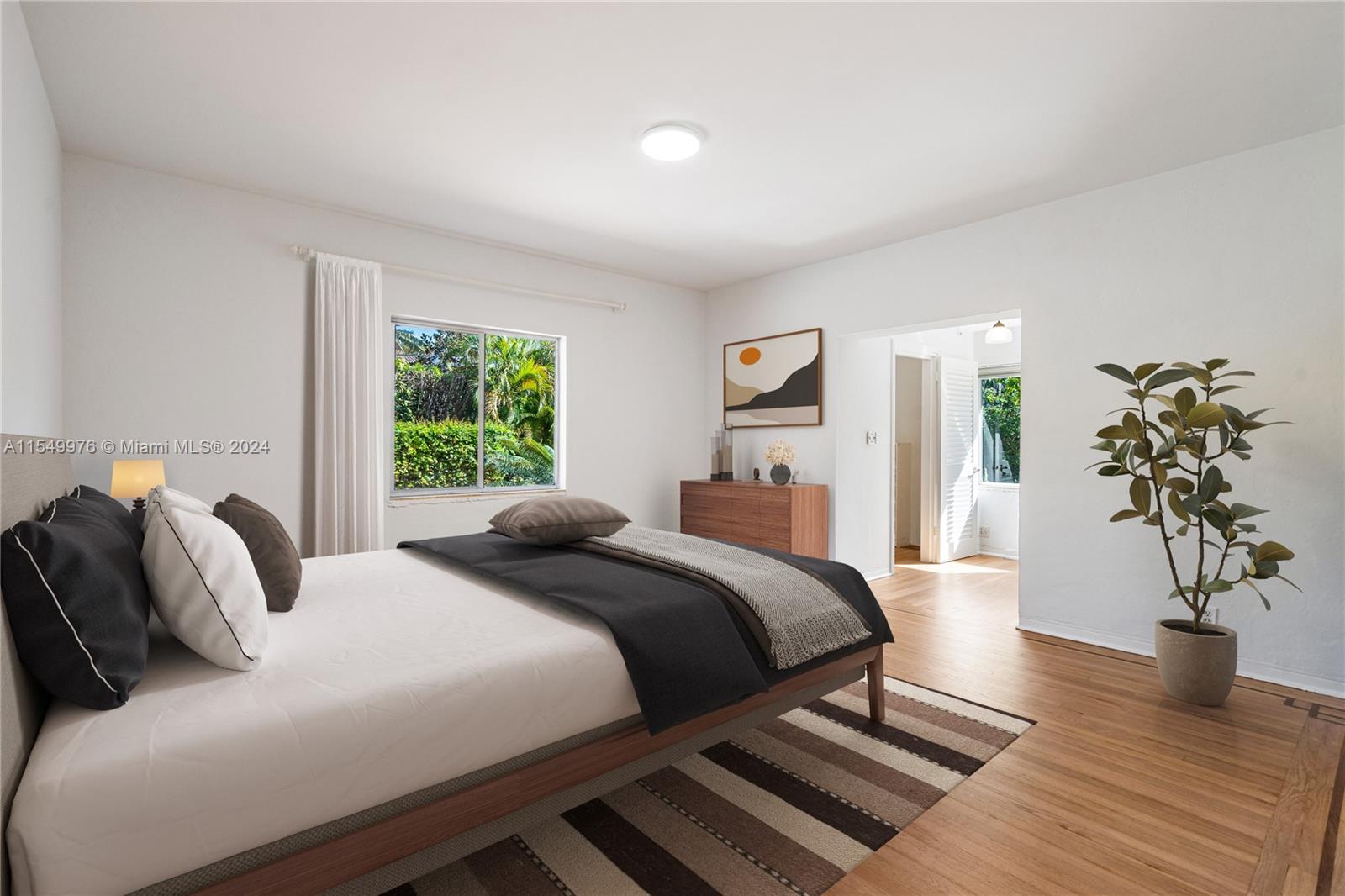 2935 North Bay Road Miami Beach, FL 33140 - Photo 5 of 36 a bedroom with a large bed and a potted plant