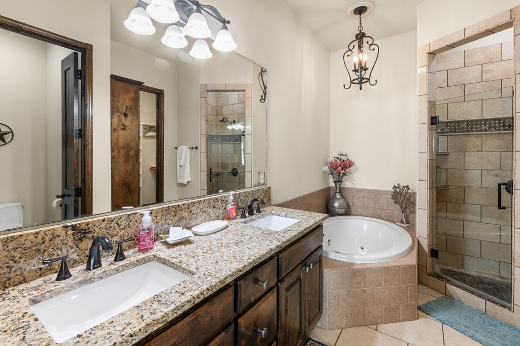 3801-1 Club House Road Kerrville, TX 78028 - Photo 11 of 26 a bathroom with a granite countertop bathtub sink and mirror
