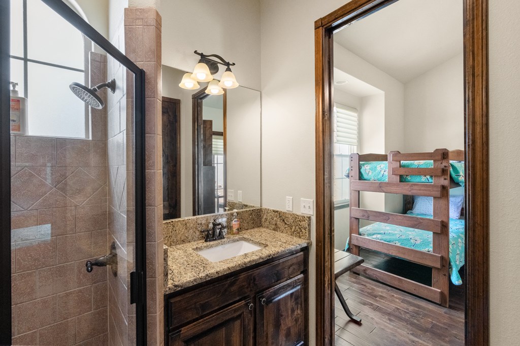 3801-1 Club House Road Kerrville, TX 78028 - Photo 18 of 26 a bathroom with a granite countertop sink and a mirror