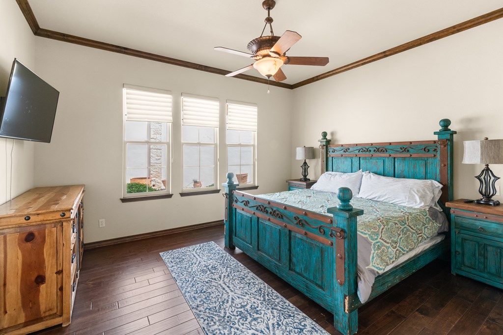 3801-1 Club House Road Kerrville, TX 78028 - Photo 9 of 26 a bedroom with a bed and a chandelier
