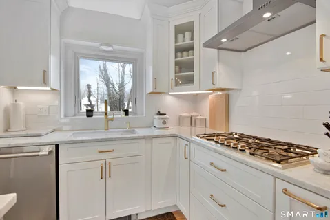 a kitchen with white cabinets and appliances