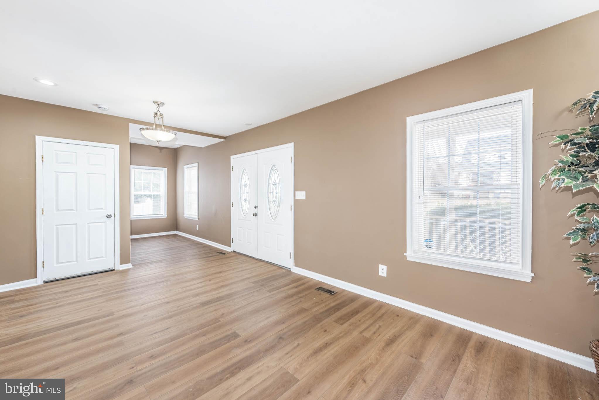 4021 Barrington Road Baltimore, MD 21207 - Photo 3 of 50 a view of an empty room with wooden floor and a window