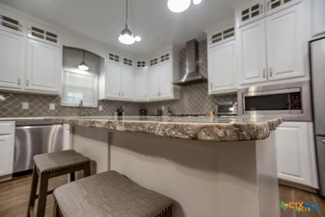a kitchen with stainless steel appliances granite countertop a sink a stove and a refrigerator
