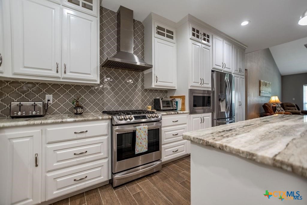 802 Mc Donald Road Port Lavaca, TX 77979 - Photo 17 of 44 a kitchen with stainless steel appliances granite countertop a stove a sink and a refrigerator