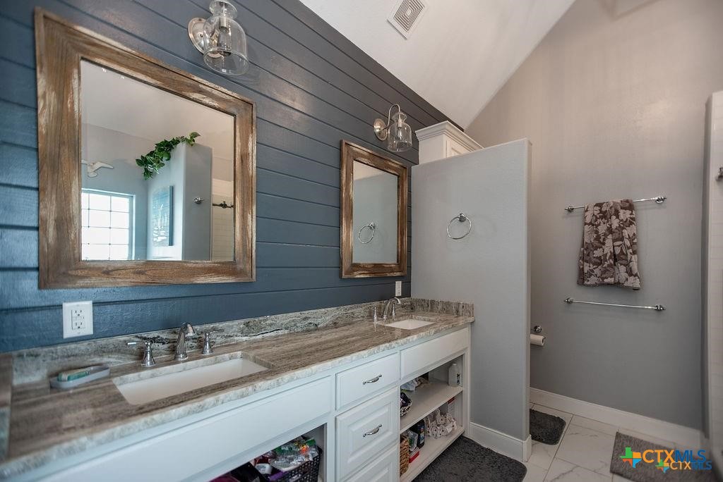 802 Mc Donald Road Port Lavaca, TX 77979 - Photo 25 of 44 a bathroom with a granite countertop sink a large mirror and a