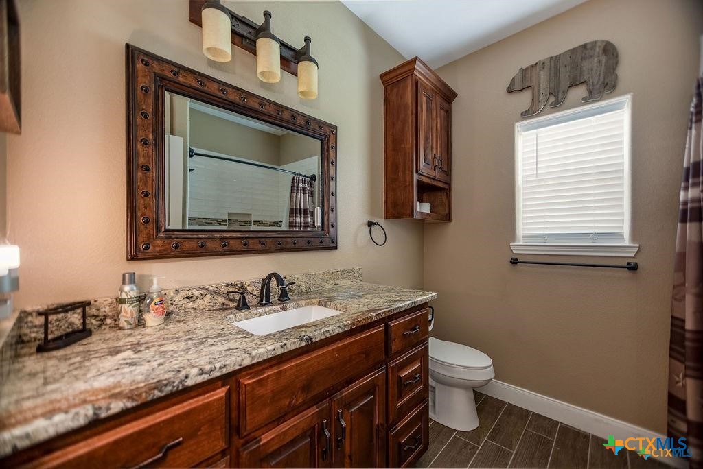 802 Mc Donald Road Port Lavaca, TX 77979 - Photo 33 of 45 a bathroom with a granite countertop toilet sink and mirror