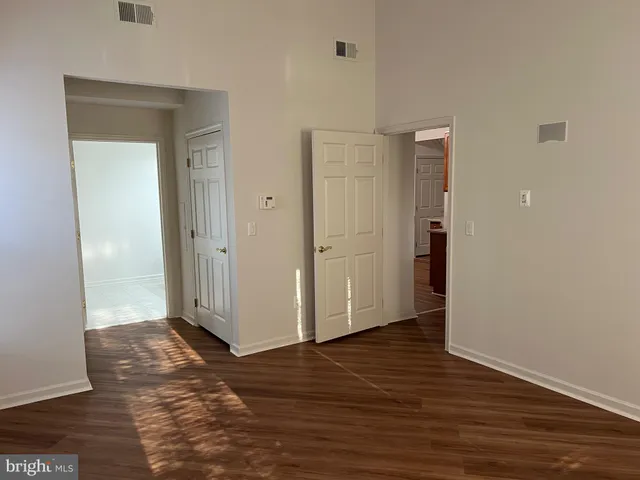 a view of a hallway with wooden floor and a living room