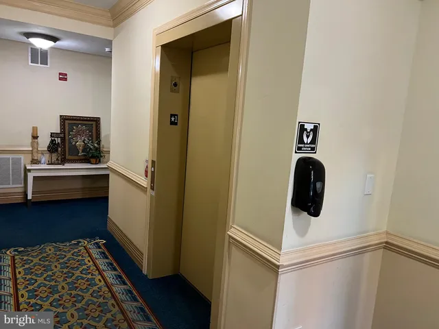 a view of an empty room with wooden floor fireplace and a window