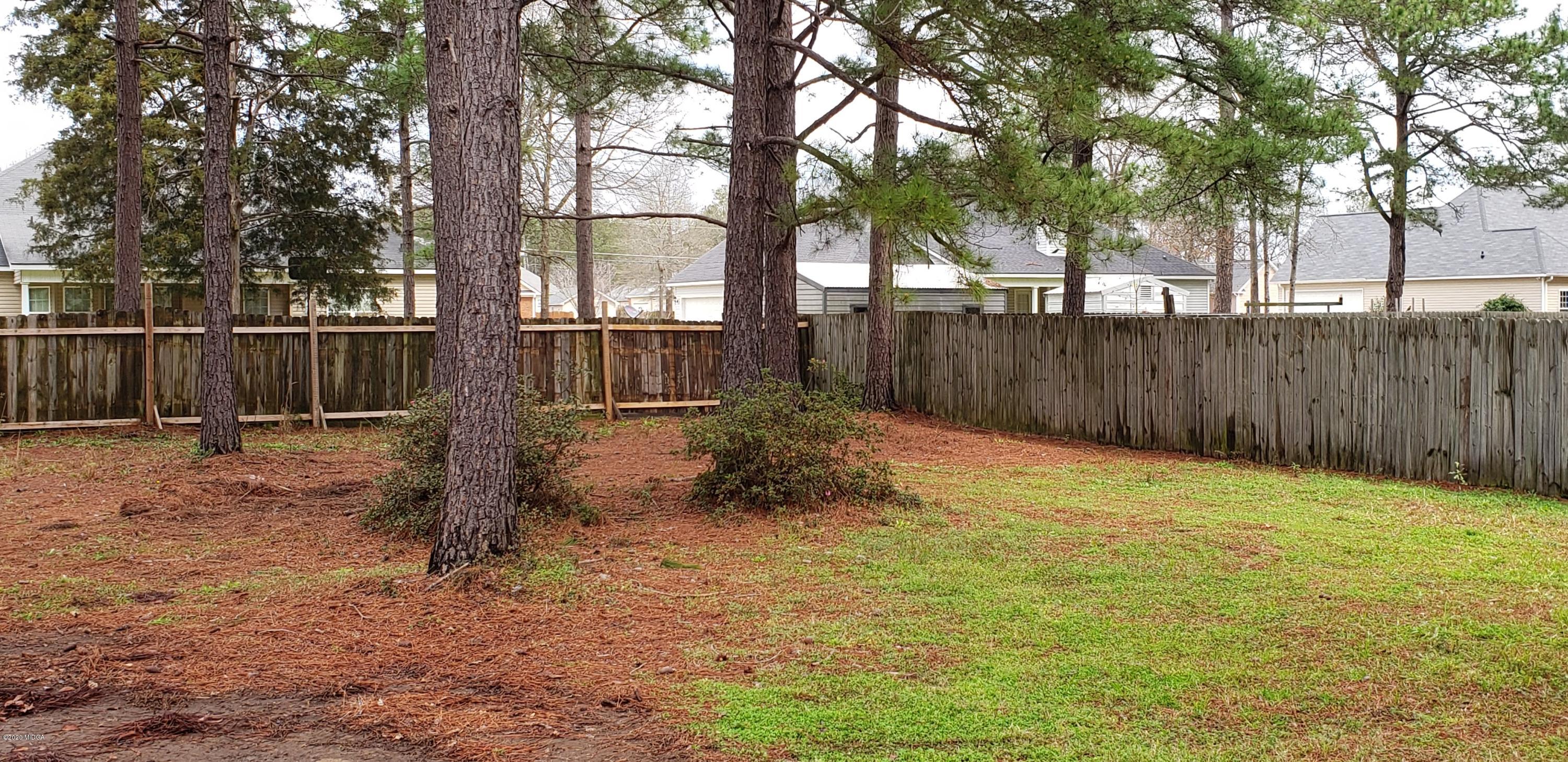 515 Amanda Way Macon, GA 31216 - Photo 32 of 33 a backyard of a house with large trees and wooden fence