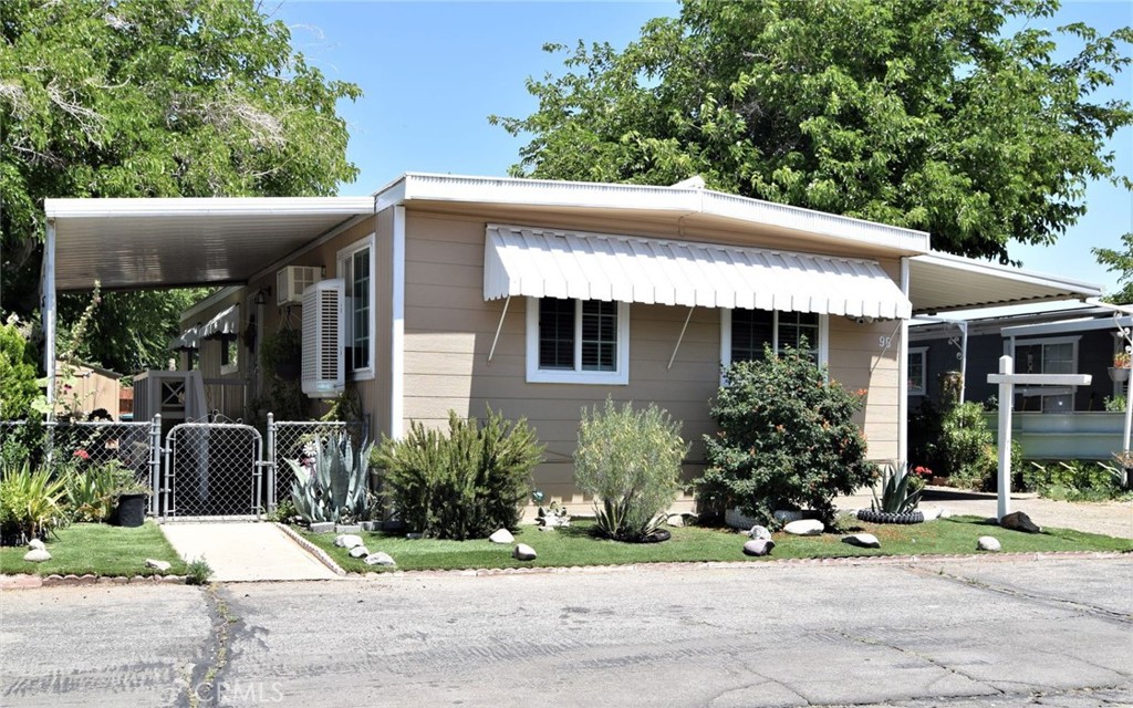 3255 East Avenue R, Unit 98 Littlerock, CA 92550 - Photo 2 of 12 a front view of a house with a garden
