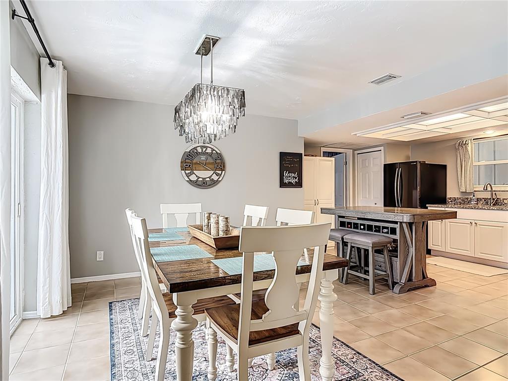 4748 Dixie Drive Ponce Inlet, FL 32127 - Photo 12 of 53 a view of a dining room with furniture a kitchen and chandelier
