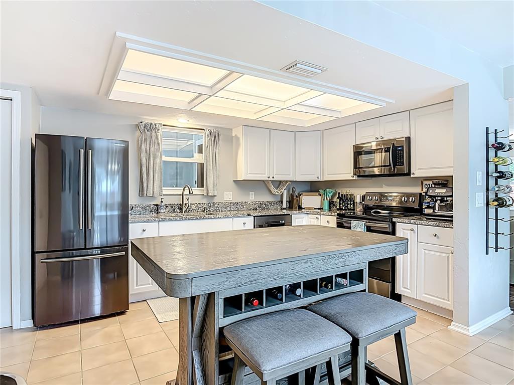 4748 Dixie Drive Ponce Inlet, FL 32127 - Photo 15 of 53 a kitchen with kitchen island a sink counter and stainless steel appliances