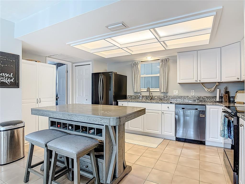 4748 Dixie Drive Ponce Inlet, FL 32127 - Photo 16 of 53 a kitchen with granite countertop a stove a sink and a refrigerator